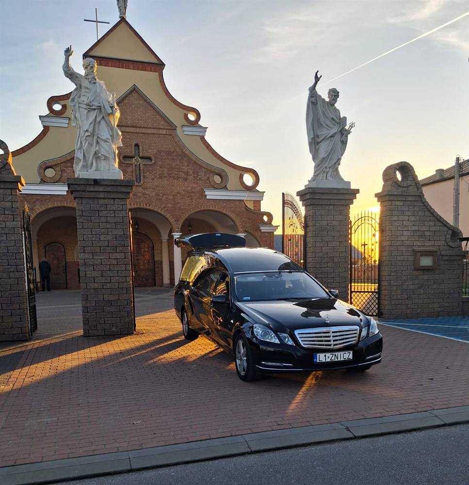 Karawan Znicza przed kościołem o zachodzie słońca